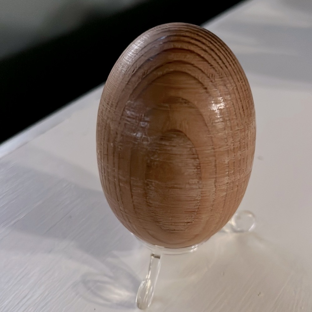 Vintage hand carved wooden egg with plastic stand